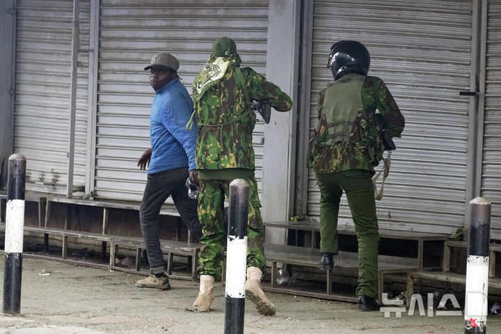 <font style="vertical-align: inherit;"><font style="vertical-align: inherit;">[나이로비=AP/뉴시스] 17일(현지 시간) 케냐 나이로비에서 최근 반정부 블로거 오즈왕이 구금 중 의문사한 것을 두고 진상 규명을 요구하는 대규모 시위가 열린 가운데 경찰이 민간인 추정 남성을 향해 총을 겨누고 있다. 2025.06.18.</font></font>