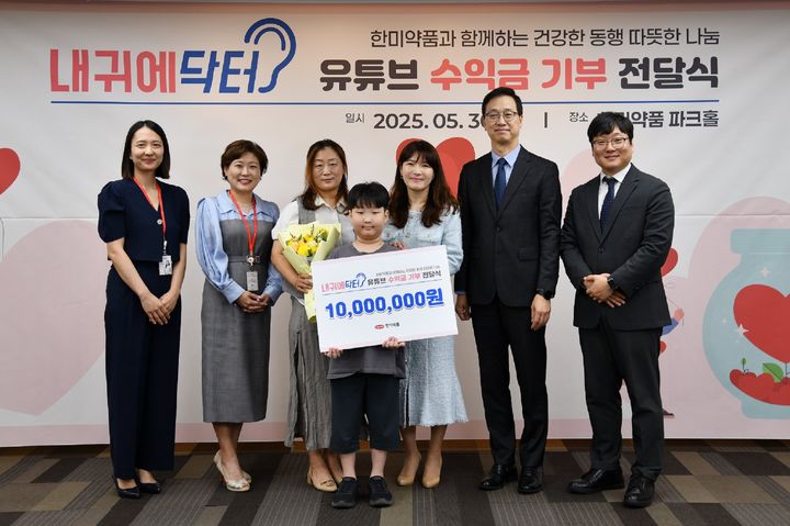 [서울=뉴시스] 지난달 30일 한미약품 본사에서 열린 '내귀에닥터 기부식' 에서 한미약품 직원 및 환우 가족이 기념촬영을 하고 있다. 왼쪽부터 박보람 파트장(디지털마케팅팀), 박명희 전무(국내사업본부), 환우가족, 김현정 상무(디지털마케팅팀), 한미약품 박재현 대표이사, 정민우 그룹장(디지털마케팅팀) (사진=한미약품 제공) 2025.06.18. photo@newsis.com *재판매 및 DB 금지