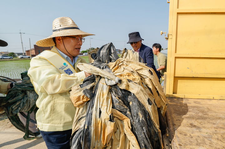 정헌율 익산시장이 18일 비닐하우스 주변과 농경지 배수로에 방치된 폐비닐 등을 수거하고 있다. (사진=익산시 제공) *재판매 및 DB 금지