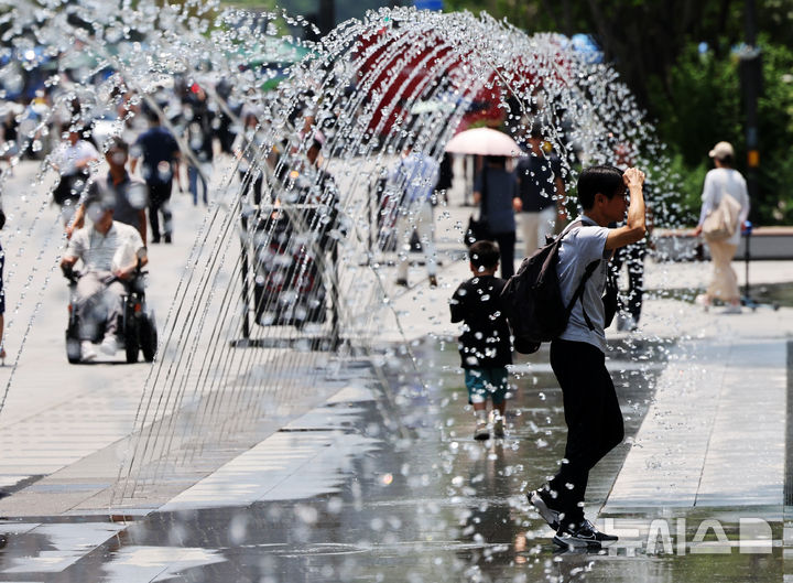 [서울=뉴시스] 배훈식 기자 = 서울 낮 최고기온 31도 등 전국이 30도 안팎의 무더운 날씨를 보인 지난 18일 오후 서울 종로구 광화문광장에서 더위를 식혀주는 바닥분수 물줄기 사이로 시민들이 발걸음을 옮기고 있다. 2025.06.18. dahora83@newsis.com