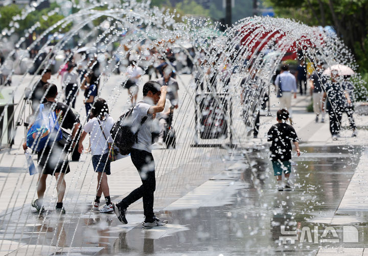 [서울=뉴시스] 배훈식 기자 = 서울 낮 최고기온 31도 등 전국이 30도 안팎의 무더운 날씨를 보인 지난 18일 오후 서울 종로구 광화문광장에서 더위를 식혀주는 바닥분수 물줄기 사이로 시민들이 발걸음을 옮기고 있다. 2025.06.18. dahora83@newsis.com