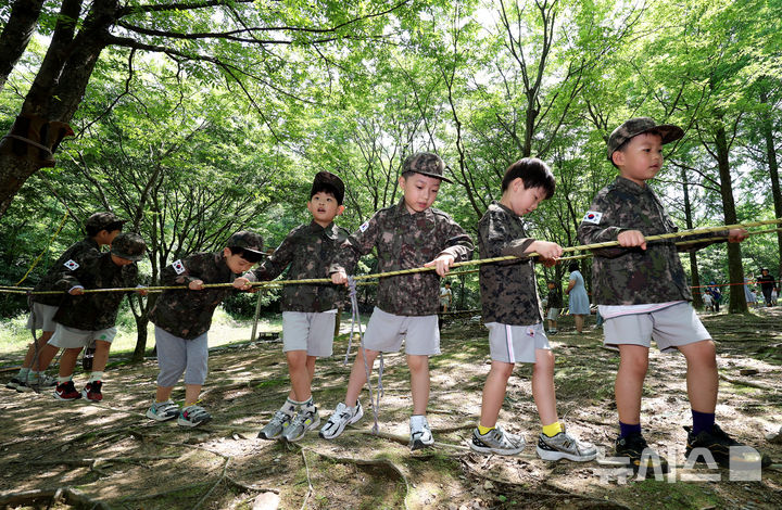 [대구=뉴시스] 이무열 기자 = 18일 대구 북구 옻골공원에서 한국자유총연맹 대구북구지회 주최로 열린 ‘6.25전쟁 당시 음식 재현 시식회 및 어린이 병영 숲 체험전 및 어린이 병영 체험전’에 참가한 어린이들이 군복을 입고 병영체험을 하고 있다. 2025.06.18. lmy@newsis.com