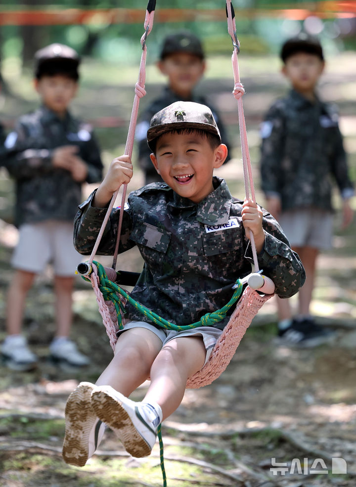 [대구=뉴시스] 이무열 기자 = 18일 대구 북구 옻골공원에서 한국자유총연맹 대구북구지회 주최로 열린 ‘6.25전쟁 당시 음식 재현 시식회 및 어린이 병영 숲 체험전 및 어린이 병영 체험전’에 참가한 어린이들이 군복을 입고 병영체험을 하고 있다. 2025.06.18. lmy@newsis.com