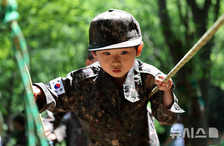 [대구=뉴시스] 이무열 기자 = 18일 대구 북구 옻골공원에서 한국자유총연맹 대구북구지회 주최로 열린 ‘6.25전쟁 당시 음식 재현 시식회 및 어린이 병영 숲 체험전 및 어린이 병영 체험전’에 참가한 어린이들이 군복을 입고 병영체험을 하고 있다. 2025.06.18. lmy@newsis.com