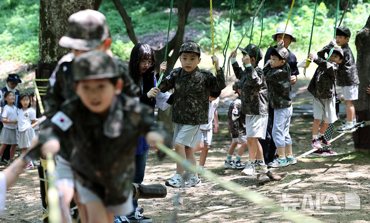 [대구=뉴시스] 이무열 기자 = 18일 대구 북구 옻골공원에서 한국자유총연맹 대구북구지회 주최로 열린 ‘6.25전쟁 당시 음식 재현 시식회 및 어린이 병영 숲 체험전 및 어린이 병영 체험전’에 참가한 어린이들이 군복을 입고 병영체험을 하고 있다. 2025.06.18. lmy@newsis.com