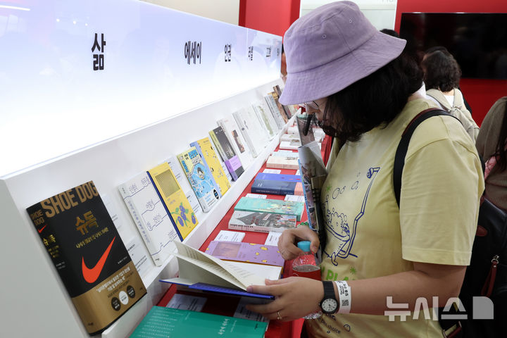 [서울=뉴시스] 박진희 기자 = 세계인의 책 잔치 '2025 서울국제도서전'이 열린 18일 서울 강남구 코엑스 행사장을 찾은 관람객들이 전시 도서를 살펴보고 있다. 올해 도서전에는 한국을 포함해 17개국의 530여 개 출판사와 출판 관련 단체 등이 참가한다. 2025.06.18. pak7130@newsis.com