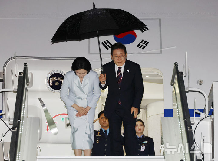 [캘거리=뉴시스] 최진석 기자 = 주요 7개국(G7) 정상회의 참석을 마친 이재명 대통령과 부인 김혜경 여사가 17일(현지 시간) 캐나다 앨버타주 캘거리국제공항에 도착해 공군 1호기에 탑승하며 인사하고 있다. 2025.06.18. myjs@newsis.com