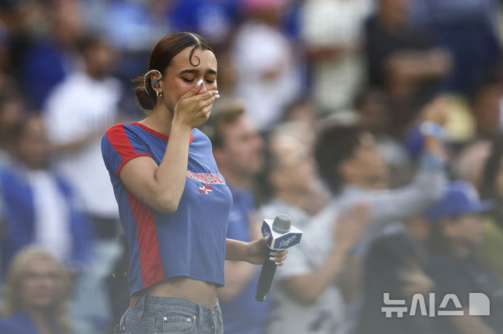 [로스앤젤레스=AP/뉴시스] 라틴 팝 가수인 네자가 15일(한국 시간) 미국 캘리포니아주 로스앤젤레스의 다저스타디움에서 벌어진 2025 메이저리그(MLB) LA 다저스와 샌프란시스코 자이언츠의 경기 전 스페인어로 미국 국가를 부른 뒤 슬픈 표정을 짓고 있다. 2025.06.15