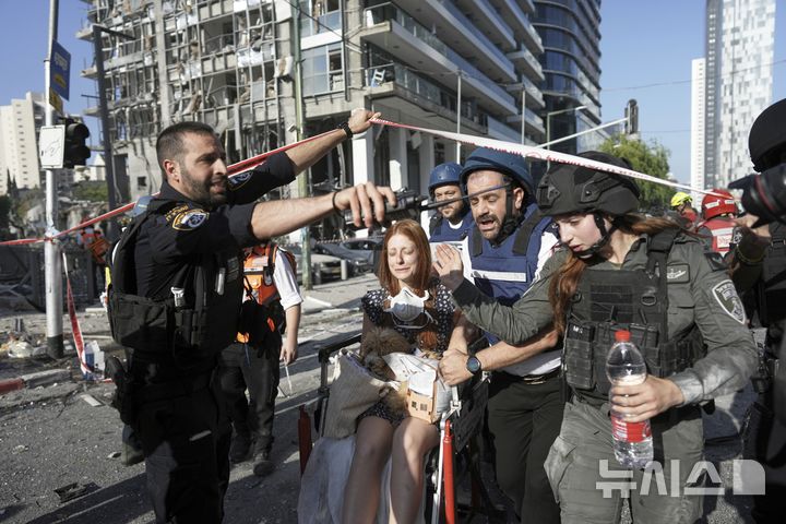 <font style="vertical-align: inherit;"><font style="vertical-align: inherit;">[라마트간=AP/뉴시스] 19일(현지 시간) 이스라엘 라마트간에서 이란 미사일 공격으로 피해를 입은 현장에서 한 여성이 대피하고 있다. 2025.06.19.</font></font>