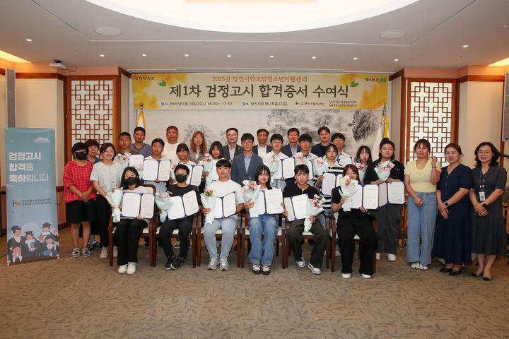 [당진=뉴시스] 충남 당진시청 해나루홀에서 올해 1차 검정고시에 합격한 학생과 부모들이 황침현(가운데 짙은 남색 정장) 부시장으로부터 합격등서를 받은 뒤 기념 사진을 찍고 있다. (사진=당진시 제공) 2025.06.19. photo@newsis.com *재판매 및 DB 금지