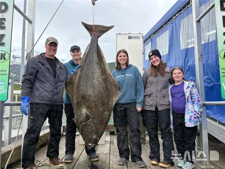 [서울=뉴시스] 일링워스 부부가 자신들이 낚은 71kg에 달하는 대광어 옆에서 웃으며 사진을 찍고 있다. (사진=알래스카뉴스소스) 2025.06.17. 