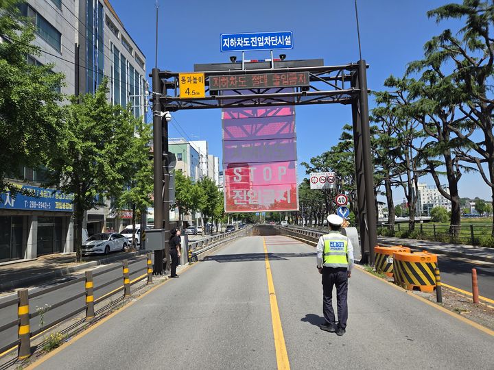 [전주=뉴시스] 19일 전북 전주시 완산구 서신동 서신지하차도에서 진행된 교통통제 훈련에서 한 경찰관이 침수 상황을 가정해 내려오는 차량 진입 차단시설을 살펴보고 있다. (사진=전북경찰청 제공) 2025.06.19. photo@newsis.com *재판매 및 DB 금지