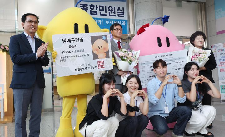 [대전=뉴시스] 조명휘 기자 = 대전시의 대표 캐릭터인 꿈돌이·꿈순이가 동구에 전입신고를 마치고 명예시민에 위촉된 뒤 구청장 등과 기념사진을 찍고 있다. (사진= 동구청 제공) 2025.06.19. photo@newsis.com *재판매 및 DB 금지