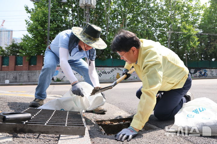 [의왕=뉴시스] 안치권 부시장이 직접 빗물받이 준설 작업을 벌이고 있다. (사진=의왕시 제공). 2025.06.19.photo@newsis.com