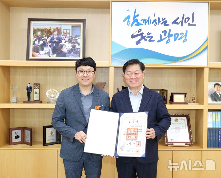 [광명=뉴시스]박승원 광명시장(사진 오른쪽)이 2025년 5월26일 시장 집무실에서 2025년 제5회 적극행정 유공 정부포상 근정포장을 수상한 이현우 주무관을 격려하고, 함께 기념촬영을 하고 있다.(사진=광명시 제공)2025.06.19.photo@newsis.com