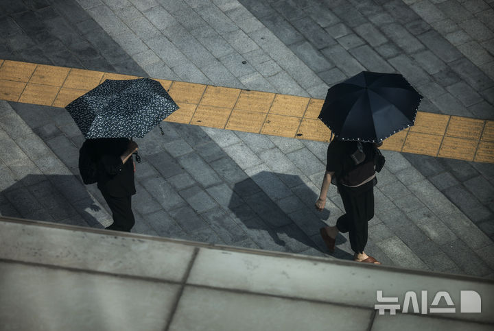 [서울=뉴시스] 정병혁 기자 = 전국이 30도 안팎의 무더운 날씨를 보인 19일 서울 중구 을지로입구역 인근에서 양산을 쓴 시민들이 이동하고 있다. 2025.06.19. jhope@newsis.com