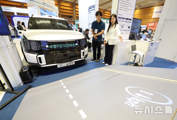 [서울=뉴시스] 김진아 기자 = 19일 서울 강남구 코엑스에서 열린 2025 국토교통기술교류회 한국교통안전공단(TS)부스에서 관계자들이 자율주행차 주행 상태를 보행자에 전달할 수 있는 'V2H 커뮤니케이션' 기술을 시연하고 있다. 2025.06.19. bluesoda@newsis.com