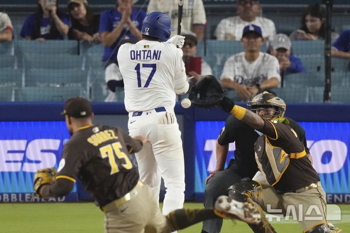 [로스앤젤레스=AP/뉴시스] LA 다저스의 오타니 쇼헤이가 20일(한국 시간) 미국 캘리포니아주 로스앤젤레스의 다저스타디움에서 벌어진 2025 MLB 샌디에이고 파드리스와의 경기에서 로베르트 수아레스가 던진 공에 맞고 있다. 2025.06.20