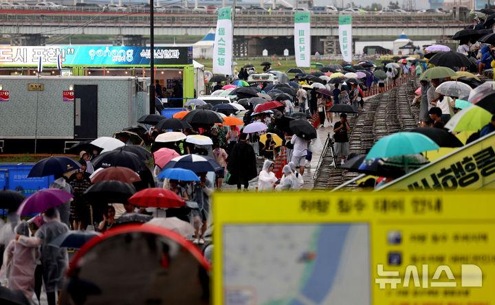 [포항=뉴시스] 이무열 기자 = 21일 오후 경북 남구 포항시 형산강 체육공원에서 열릴 예정이었던 ‘2025 포항국제불빛축제’가 장맛비에 취소되자 관람객들이 철수하고 있다.  포항시는 이날 호우주의보가 발령됨에 따라 국제불꽃쇼, 드론라이트쇼 등 주요 행사를 모두 취소했다. 2025.06.21. lmy@newsis.com
