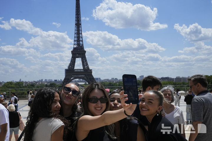 [서울=AP/뉴시스] 프랑스 파리를 찾은 관광객들이 에펠탑을 배경으로 사진을 찍고 있다. 2023.07.06