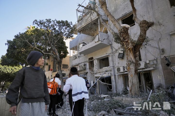 [하이파=AP/뉴시스] 24일(현지 시간) 워싱턴포스트, CNN 등 외신에 따르면 이란 대통령 마수드 페제시키안은 이날 성명을 통해 "이스라엘이 휴전 조건을 준수하는 한, 이란도 트럼프 대통령이 발표한 휴전 합의를 위반하지 않을 것"이라고 밝혔다. 사진은 22일(현지 시간) 이스라엘 하이파에서 주민들이 이란의 미사일 공격 현장을 살펴보고 있는 모습. 2025.06.25.