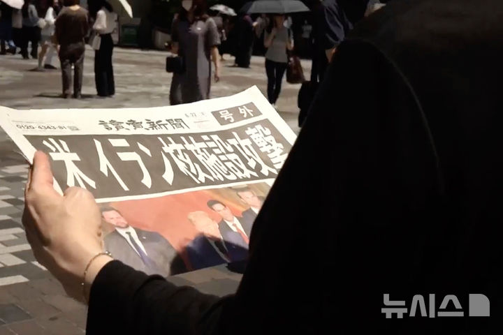 [도쿄=AP/뉴시스] 22일 일본 도쿄에서 한 행인이 미국의 이란 핵시설 공격을 전한 특별판 신문을 들고 있다. 신문의 머리기사는 "미국, 이란 핵시설 공격"이라고 쓰여 있다. 2025.06.23. photo@newsis.com