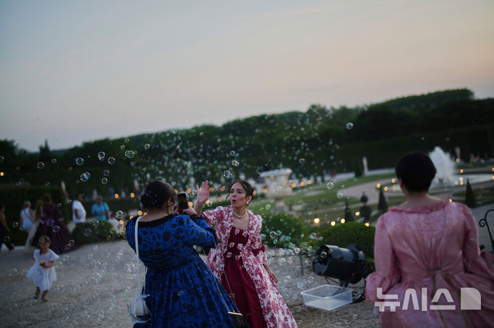 <font style="vertical-align: inherit;"><font style="vertical-align: inherit;">[베르사유=AP/뉴시스] 21일(현지 시간) 프랑스 파리 베르사유 궁전에서 열린 가면 무도회에 참가한 참가자들이 기념촬영을 하고 있다. 2025.06.23.</font></font>