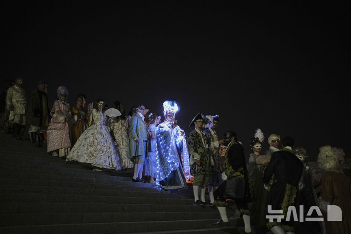 [베르사유=AP/뉴시스] 21일(현지 시간) 프랑스 파리 베르사유 궁전 오랑주리에서 열린 가면 무도회에 참가한 참가자들이 이동하고 있다. 2025.06.23.