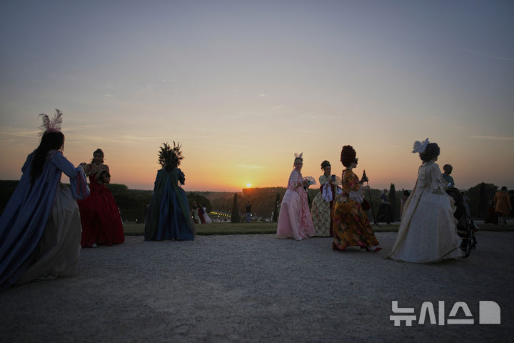 [베르사유=AP/뉴시스] 21일(현지 시간) 프랑스 파리 베르사유 궁전 오랑주리에서 열린 가면 무도회에 참가한 참가자들이 이동하고 있다. 2025.06.23.