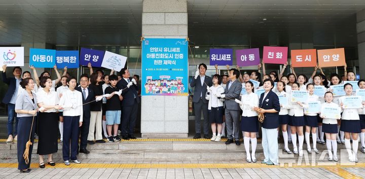 [안양=뉴시스] 아동 친화 도시 선포식 참석자들이 다 함께 모여 시청 현관문 앞에서 현판식을 열고 있다. (사진=안양시 제공).2025.06.22. photo@newsis.com 
