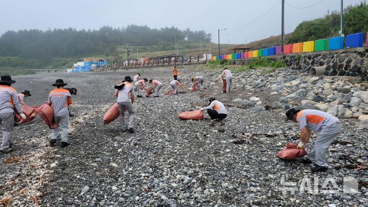 [제주=뉴시스] 제주소방안전본부가 21일 도내 해수욕장에서 플로깅 행사를 열고 쓰레기를 줍고 있다. (사진=제주소방안전본부 제공) 2025.06.21. photo@newsis.com 
