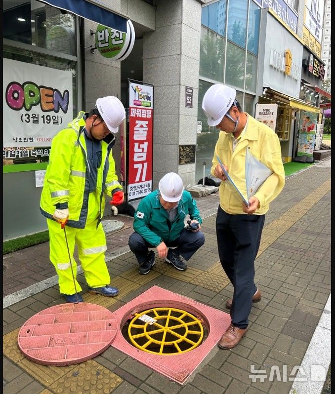 [시흥=뉴시스] 박승삼 부시장(사진 가운데)이 풍수해에 대비해 도로 등에 설치된 히수도 맨홀 상태를 동행한 공무원들과 점검하고 있다. (사진=시흥시 제공)..2025.06.22. photo@newsis.com