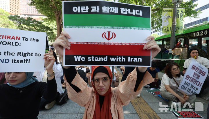 [서울=뉴시스] 추상철 기자 = 트럼프 미국 대통령이 이란의 주요 핵 시설을 파괴했다고 밝힌 22일 오후 서울 종로구 교보빌딩 인근에서 열린 노동자연대의 '전쟁 중단 및 이스라엘 공격 규탄집회'에서 이란인 집회 참가자가 피켓을 들고 전쟁 중단을 촉구하고 있다. 2025.06.22. scchoo@newsis.com