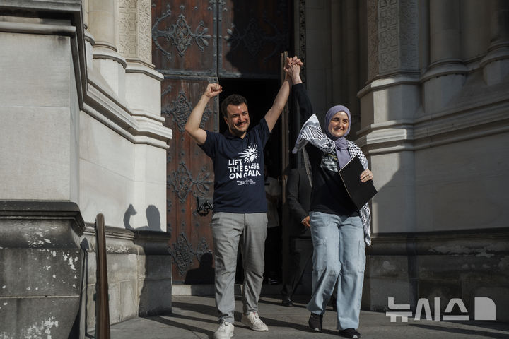 [뉴욕=AP/뉴시스]미국 컬럼비아대에서 친(親)팔레스타인 시위를 주도한 혐의로 체포돼 추방 위기에 몰렸다가, 100여일 만에 석방된 마흐무드 칼릴이 지난달 22일 미국 뉴욕에서 열린 집회에 배우자와 함께 참석해 손을 들어보이고 있다. 2025.07.11. 