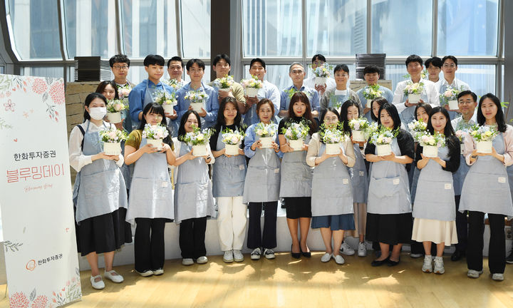 한화투자증권 한두희 대표이사(두째 줄 왼쪽 일곱번째)와 임직원들이 직접 만든 플라워 박스를 들고 기념촬영을 하고 있다. (사진=한화투자증권 제공) *재판매 및 DB 금지