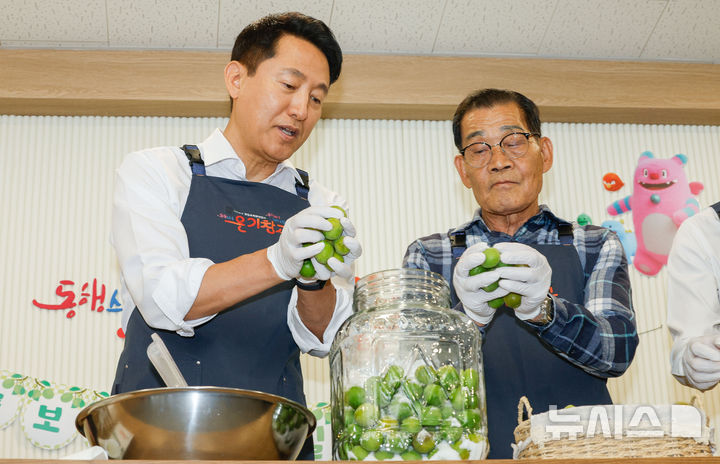 [서울=뉴시스] 홍효식 기자 = 오세훈 서울시장이 23일 서울 영등포쪽방상담소에서 열린 온기창고 개소식에서 주민대표와 매실청을 담그고 있다. (공동취재) 2025.06.23. photo@newsis.com
