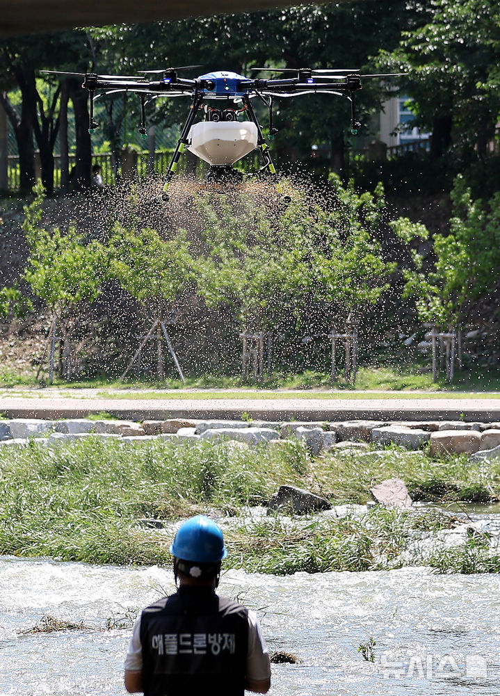 [대구=뉴시스] 이무열 기자 = 23일 대구 북구 동천교 하단에서 열린 대구시 최초 드론 방역 시연식에서 업체 관계자가 드론 방역 시연을 선보이고 있다. 2025.06.23. lmy@newsis.com