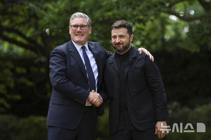 [런던=AP/뉴시스] 볼로디미르 젤렌스키(오른쪽) 우크라이나 대통령과 키어 스타머 영국 총리가 23일(현지 시간) 런던 총리 관저에서 만나 악수하고 있다. 두 정상은 정상회담 후 양국이 방위산업 공동생산에 나서기로 했다고 밝혔다. 이날 젤렌스키 대통령은 평소의 군복 대신 검은색 재킷을 입었다. 2025.06.24.
