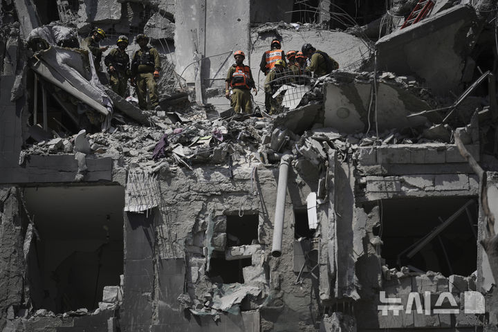 [베르셰바=AP/뉴시스] 24일(현지 시간) 이스라엘 베르셰바에서 이스라엘 군인들이 이란 미사일 공격을 받은 현장을 수습하고 있다. 2025.06.24.