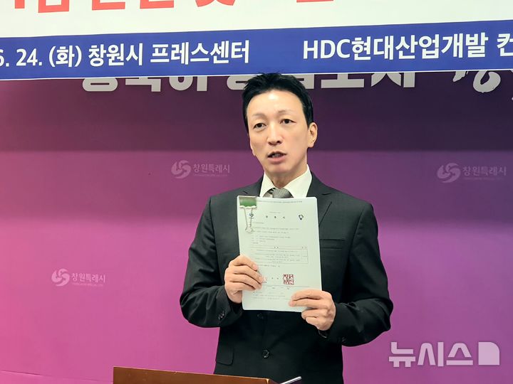 [창원=뉴시스] 강경국 기자 = 마산해양신도시 개발 사업 5차 공모 우선협상대상자인 HDC현대산업개발 컨소시엄 휴벡스피앤디 김중협 대표가 24일 경남 창원시청 프레스센터에서 기자회견을 하던 중 창원시가 법원에 제출한 감사보고서를 공개하고 있다. 2025.06.24. kgkang@newsis.com