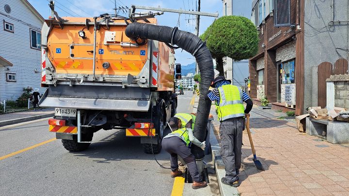 [동해=뉴시스] 동해시가 다목적차량(유니목)과 건설과 소속 현장대응 기동처리반을 투입해 빗물받이에 쌓인 토사 등 퇴적물을 제거하고 있다.(사진=동해시 제공)photo@newsis.com *재판매 및 DB 금지