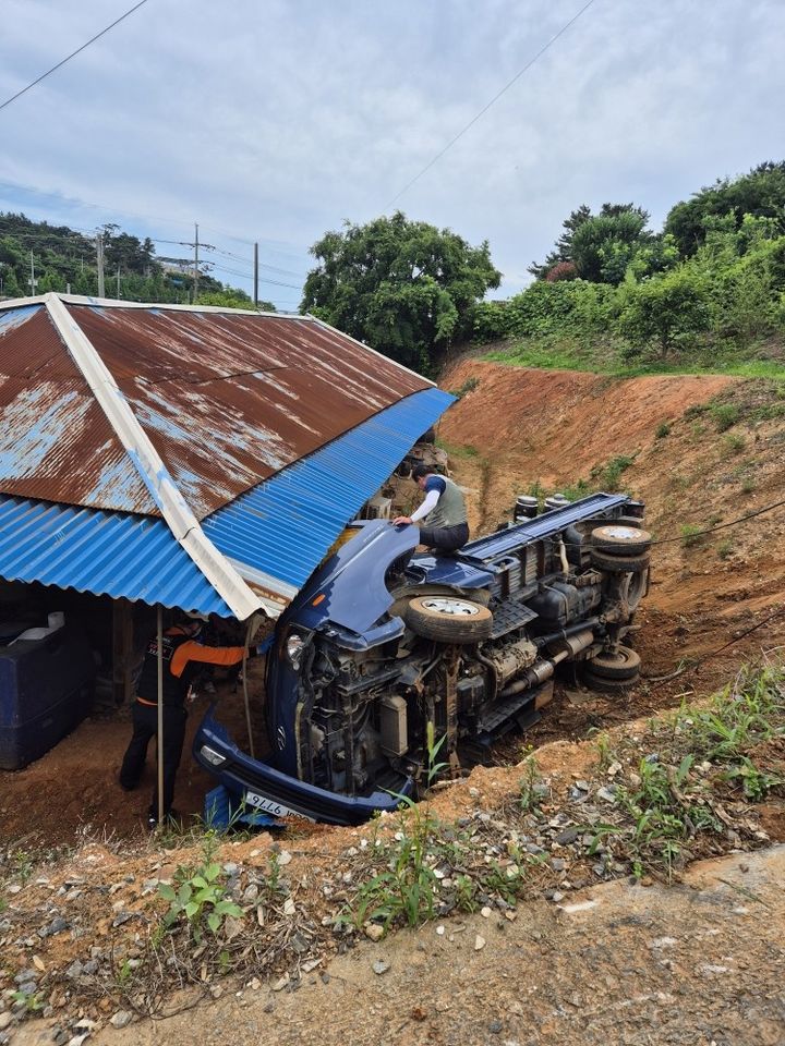 [태안=뉴시스] 24일 오전 10시21분께 충남 태안군 남면 신온리의 한 단독주택 뒷길에서 후진하던 1t 트럭이 5m 아래로 굴러 떨어진 후 전도돼 현장에 출동한 소방대원이 운전자 구조에 나서고 있다. (사진=태안소방서 제공) 2025.06.24. photo@newsis.com *재판매 및 DB 금지