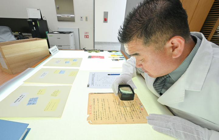 [서울=뉴시스] 23일 충남 계룡대 육군기록정보관리단에서 열린 중요 역사기록물 복원사업 현장 공개에서 복원 관계관이 확대경을 이용해 보전 기록물의 손상도를 확인하고 있다. (사진=육군 제공) 2025.06.24. photo@newsis.com *재판매 및 DB 금지