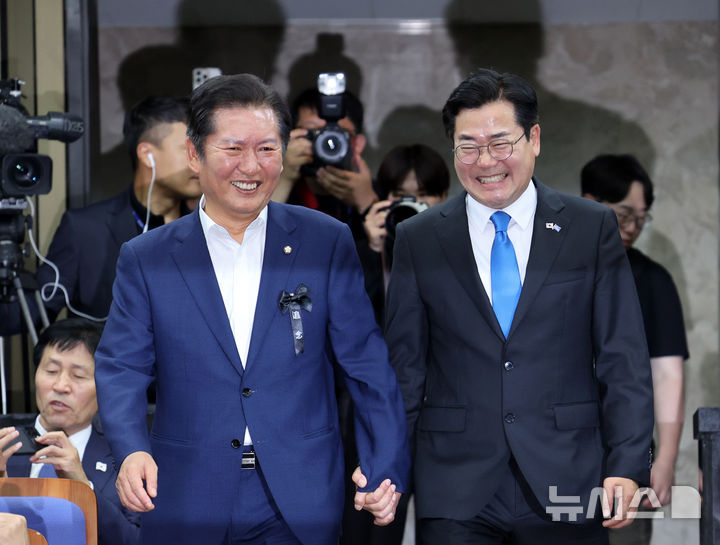 [서울=뉴시스] 김명년 기자 = 더불어민주당 당대표 출마 선언을 한 정청래(왼쪽), 박찬대 의원이 24일 오후 서울 여의도 국회에서 열린 의원총회에서 손을 잡고 입장하고 있다. 2025.06.24. kmn@newsis.com