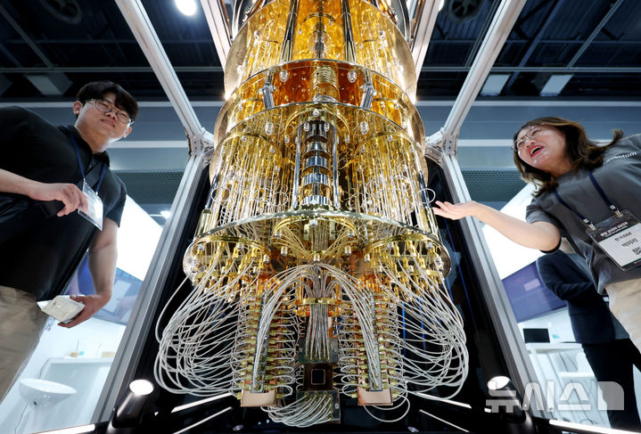 [서울=뉴시스] 김진아 기자 = 24일 서울 서초구 aT센터에서 열린 '퀀텀 코리아 2025'에서 관람객들이 IBM '퀀텀 시스템 원(Quantum System One)' 양자컴퓨터 모형에 대한 설명을 듣고 있다. 2025.06.24. bluesoda@newsis.com