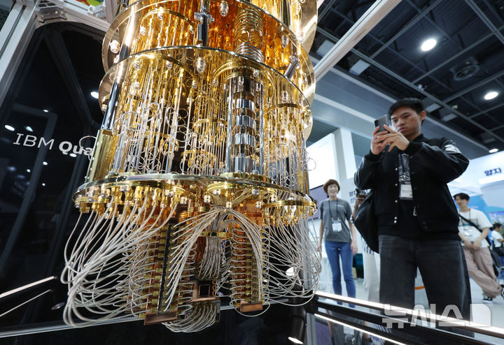 [서울=뉴시스] 김진아 기자 = 24일 서울 서초구 aT센터에서 열린 '퀀텀 코리아 2025'에서 관람객들이 IBM '퀀텀 시스템 원(Quantum System One)' 양자컴퓨터 모형에 대한 설명을 듣고 있다. 2025.06.24. bluesoda@newsis.com