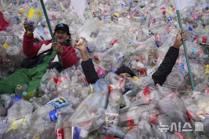 [보고타=AP/뉴시스] 24일(현지 시간) 콜롬비아 보고타의 볼리바르 광장에서 재활용품 수거 종사자들이 플라스틱병을 광장에 깔아 놓고, 재활용품 매입 업체들의 매입가가 지나치게 낮다며 항의 시위를 벌이고 있다. 2025.06.25.