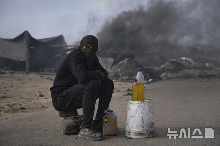 <font style="vertical-align: inherit;"><font style="vertical-align: inherit;">[가자시티=AP/뉴시스] 지난 22일(현지 시간) 가자지구 가자시티 남쪽 시로드에서 팔레스타인 청년이 플라스틱에서 추출한 연료를 판매하고 있다. 팔레스타인 청년들은 플라스틱 폐기물을 금속 드럼에 넣고 가열해 만든 연료를 병에 담아 판매하며, 이는 현지에서 발전기나 이동용 연료로 사용된다. 유독한 연기와 불길에 노출되는 고된 작업이지만, 이들에게는 가족의 생계를 이어가는 거의 유일한 수단이다. 2025.06.25.</font></font>