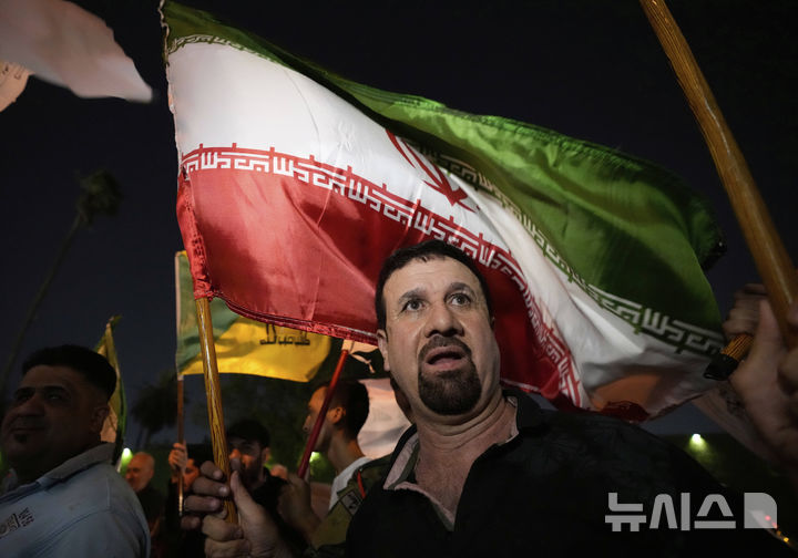 [바그다드=AP/뉴시스] 주요 7개국(G7) 외무장관들이 공동성명에서 이스라엘과 이란 휴전을 지지하며 이란 핵 프로그램 문제를 해결하기 위한 협상 재개를 촉구했다고 30일(현지 시간) 타임스오브이스라엘(TOI)이 보도했다. 사진은 지난달 24일 이라크 바그다드에서 이란 국기를 든 시위대가 이라크 주재 이란 대사관 앞에 모여 이란과 이스라엘의 휴전을 환영하는 모습. 2025.07.01.