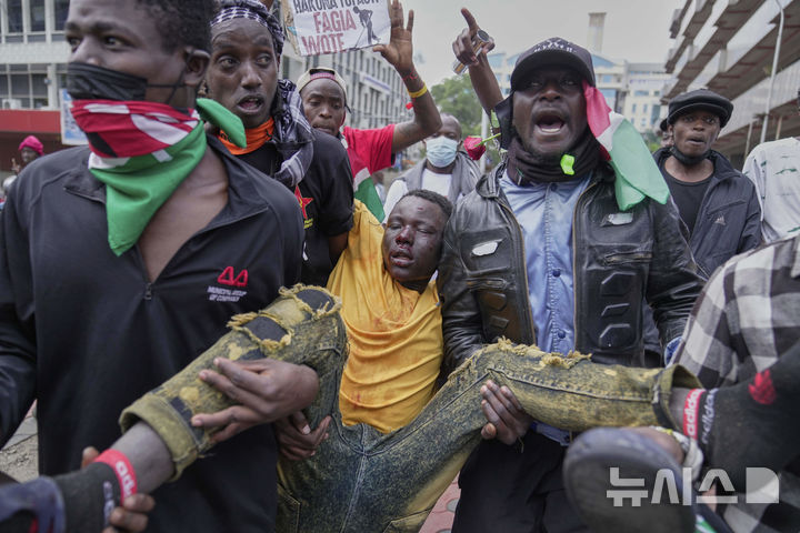 <font style="vertical-align: inherit;"><font style="vertical-align: inherit;">[나이로비=AP/뉴시스] 25일(현지 시간) 케냐 나이로비에서 열린 대규모 반정부 시위에서 경찰에 구타당한 한 남성이 이송되고 있다. 2025.06.26.</font></font>